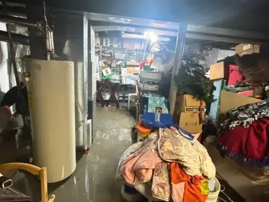 Flooded basement with stored items.
